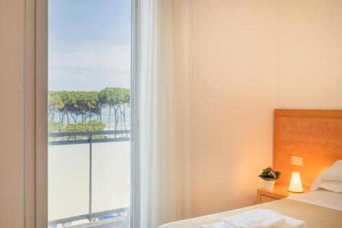 a bedroom with a window with a view of the ocean at Hotel La Pineta in Pineto