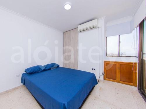 um quarto com uma cama azul e uma janela em Apartamento 1 Alcoba en Altamar 703 Cartagena em Cartagena das Índias
