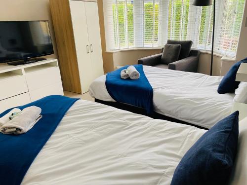 a hotel room with two beds and a television at Mayors House Ideal for Groups & Business in Peterborough