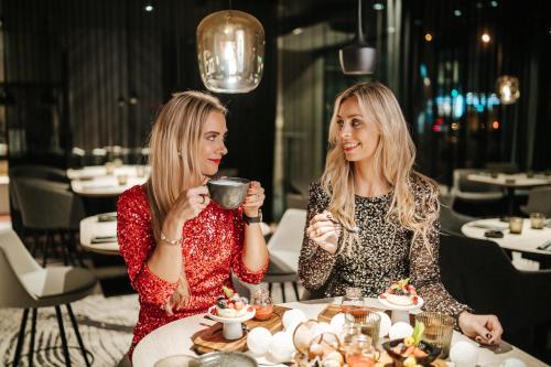 two women sitting at a table drinking coffee at Tallink City Hotel in Tallinn
