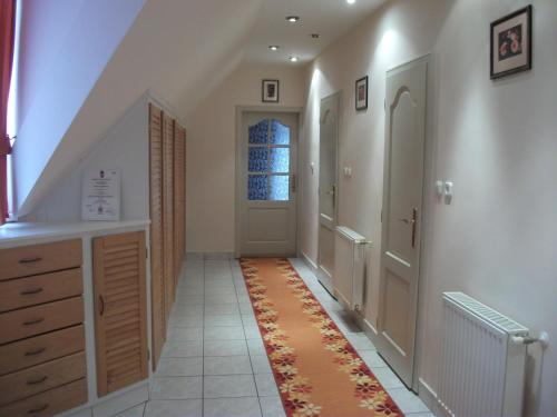 a hallway with an orange rug on the floor at Jóbor Vendégház in Győrújbarát
