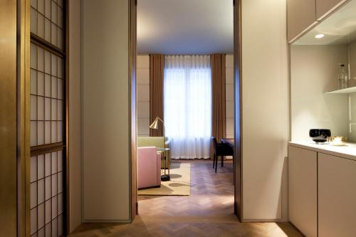 a room with a door leading to a room with a table at Hotel Cafe Royal in London