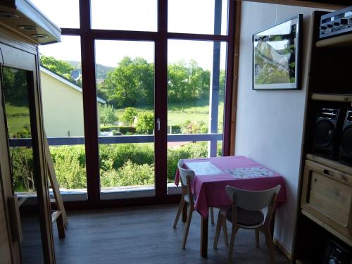 a dining room with a table and a window at Blaues Haus - Une maison bleue in Hetzerath