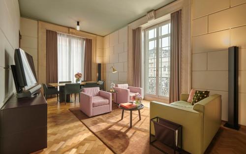 a living room with pink chairs and a tv at Hotel Cafe Royal in London