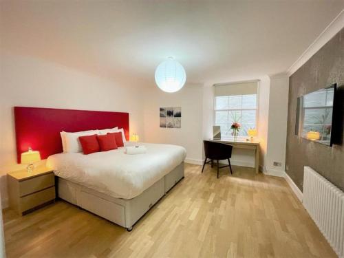 a bedroom with a large bed with a red headboard at Elite 3 Bed New Town Apt with Private Walled Garden in Edinburgh