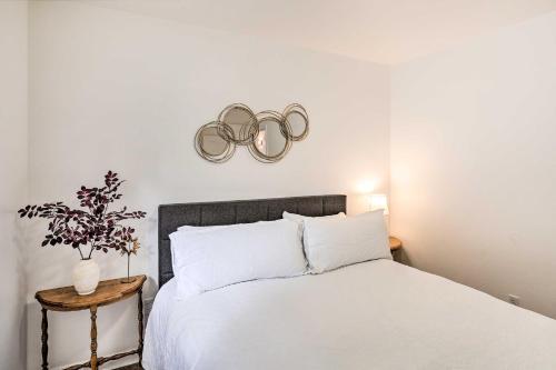 a bedroom with a white bed with two olympics on the wall at Mount Shasta Escape with Balcony about Walk to Dtwn in Mount Shasta