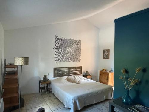 a bedroom with a bed and a painting on the wall at Oustal du pic saint loup in Saint-Jean-de-Cuculles