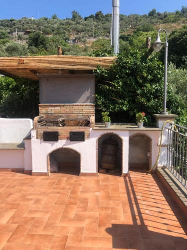 a patio with an outdoor fireplace on a house at Donna Caterì in Termini