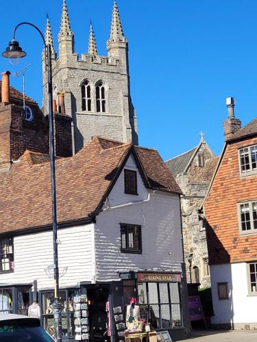 an old white building with a church in the background at Cosy Getaway ! in Kent