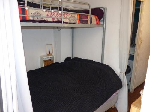 - une chambre avec des lits superposés et une couverture noire dans l'établissement Sol-y-Days Flamant, Studio avec terrasse et parking, résidence avec un accès direct à la plage, au Grau-du-Roi