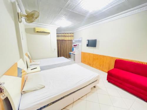 een ziekenhuiskamer met een bed en een rode bank bij Hotel New Mid City in Multan