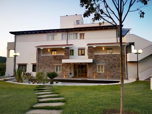 un bâtiment avec un chemin devant lui dans l'établissement Hotel Le Ginestre Family & Wellness, à Vieste