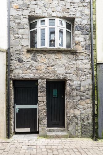 a stone building with two doors and two windows at The Snug Townhouse in Galway