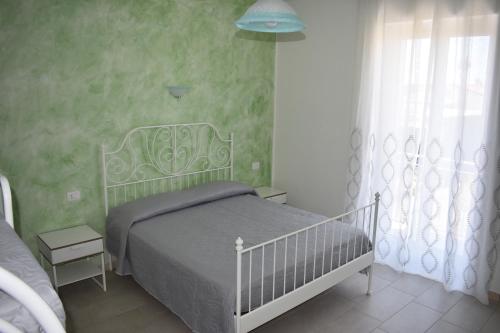 1 dormitorio con cama blanca y ventana en B&B Da Zio Peppe en Cirella