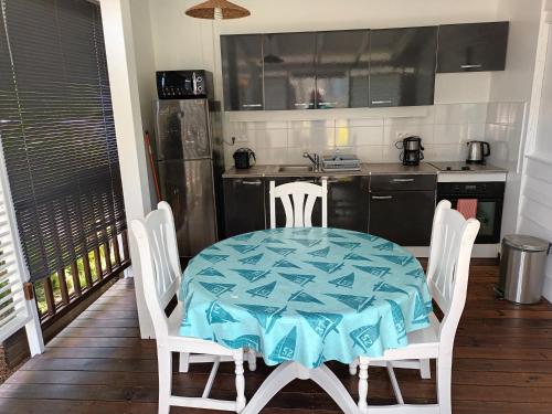a kitchen with a table and chairs and a kitchen with a table and a kitchen at la case dentelle bungalow in Le Diamant