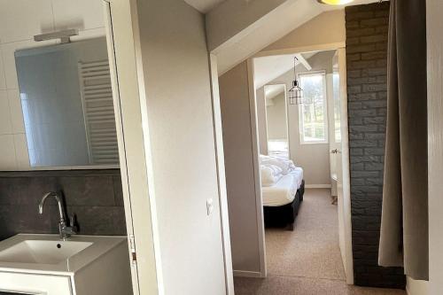 a bathroom with a sink and a bedroom with a bed at Luxe 8 persoons ‘Golfvillatexel’ vlakbij zee in De Cocksdorp