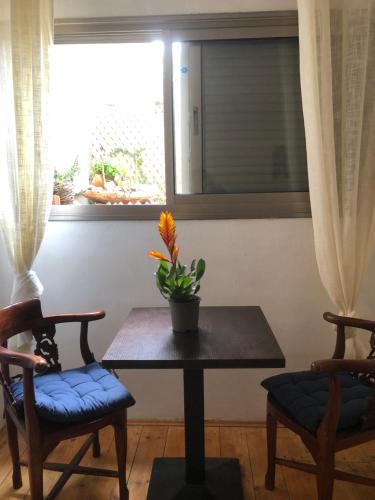 a table and two chairs in a room with a window at פינה קסומה בהר in Lotem