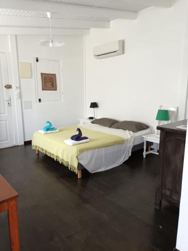 1 dormitorio con 1 cama grande con manta amarilla en la case dentelle bungalow en Le Diamant