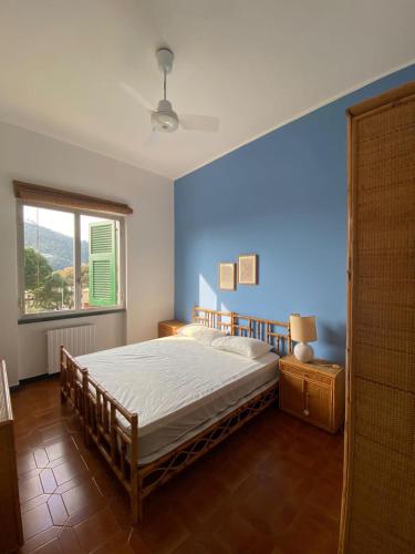 1 dormitorio con cama y pared azul en Aurea Bonassola, en Bonassola