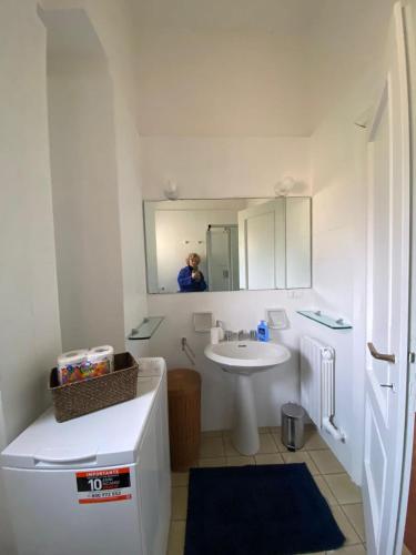uma casa de banho branca com um lavatório e um espelho em Aurea Bonassola em Bonassola