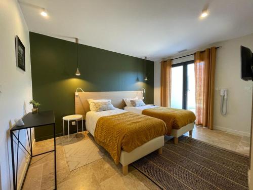 a bedroom with two beds and a green wall at Domaine Mas Terra in Saint-Paul-de-Fenouillet