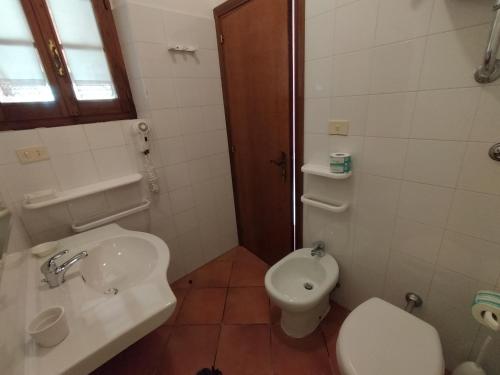 a white bathroom with a sink and a toilet at Agriturismo Bio Pian Dei Casali in Saturnia