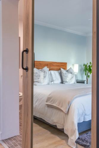 a bedroom with a large bed with a mirror at Chateau de Marine Boutique Hotel in Struisbaai