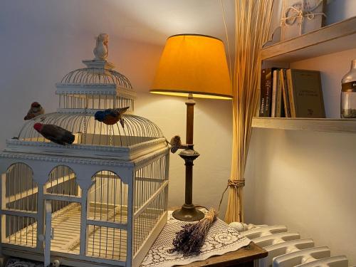 a bird cage sitting on a table next to a lamp at Mas de la Beaume in Gordes