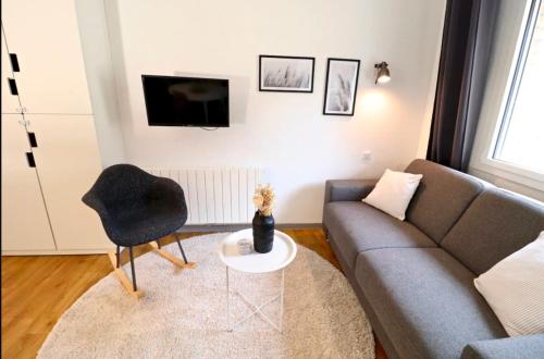 a living room with a couch and a chair at Le gardien du phare : 4 pers, balcon et parking ! in Le Touquet-Paris-Plage