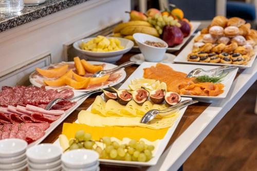 a buffet with many different types of cheese and fruit at Villa Basileia Riverside in Karlovy Vary