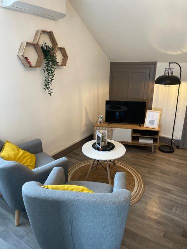 uma sala de estar com duas cadeiras e uma mesa em Joli T1 3* rénové mars 2022 proche lac et ville em Aix-les-Bains