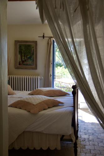 a bedroom with a bed and a window at Mas de la Beaume in Gordes