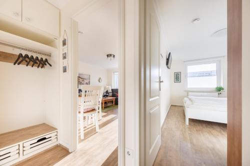 Kleines weißes Zimmer mit einem Schlafzimmer und einem Wohnzimmer. in der Unterkunft Luxus-Loft-Sylt Haus Dünenburg in Westerland