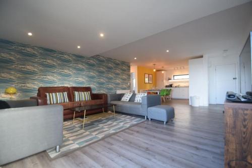 a living room with a couch and a table at Flat 1 High Tide House, Mortehoe - beautifully designed ground floor flat with sea views and garden in Mortehoe