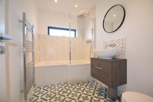 a bathroom with a sink and a mirror at Flat 1 High Tide House, Mortehoe - beautifully designed ground floor flat with sea views and garden in Mortehoe