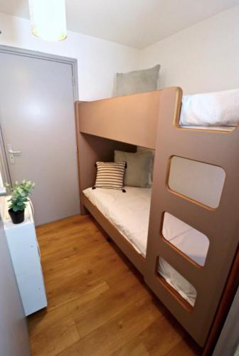 Ce lit superposé se trouve dans une petite chambre dotée de parquet. dans l'établissement Le gardien du phare : 4 pers, balcon et parking !, à Le Touquet-Paris-Plage