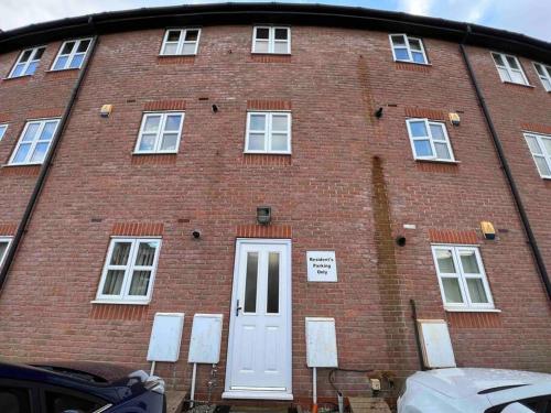 a large red brick building with a white door at Viking in Cronton