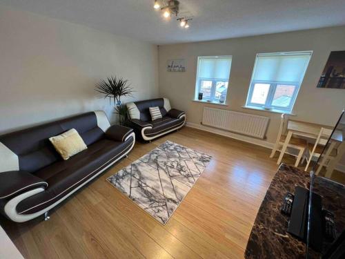 a living room with a black couch and a table at Viking in Cronton