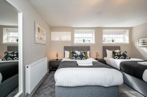 1 dormitorio con 2 camas y 2 ventanas en Host & Stay - Stunning Georgian Multi-Unit Townhouse Apartment, en Liverpool