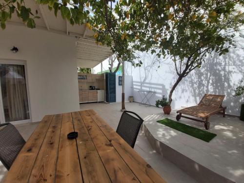 a wooden table and chairs in a room with a tree at Antonios 1 in Matala