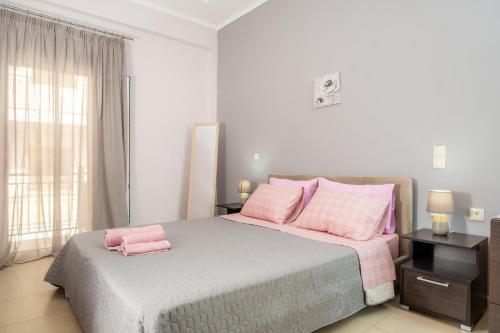 a bedroom with a large bed with pink pillows at Agios Pavlos Corner Vacation House Zakinthos in Zakynthos Town