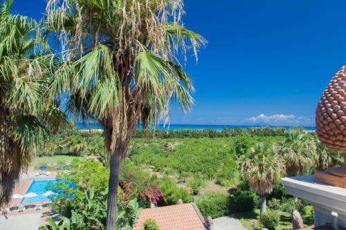 uma vista a partir da varanda de um resort com uma palmeira em Rosmarino Park em SantʼAgata di Militello