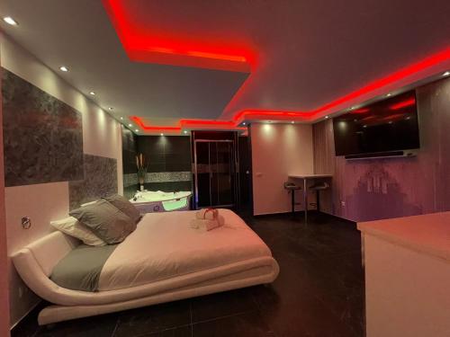 um quarto com uma cama com luzes vermelhas no tecto em La desiroom em Fréjus