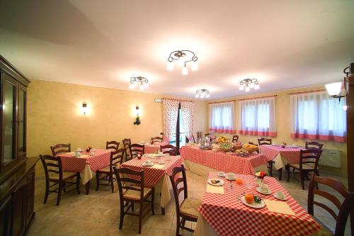 um restaurante com mesas e cadeiras vermelhas e brancas em Alloggio Franciscus em Arqua Petrarca