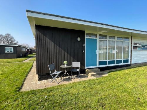 a small house with a table and two chairs at 93 Broadside Holiday Chalet near Broads & Beaches in Stalham