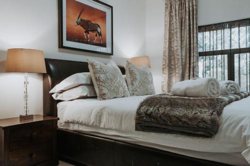 Schlafzimmer mit einem Bett mit weißer Bettwäsche und einem Fenster in der Unterkunft Bloemendal Wine Estate Accommodation in Kapstadt