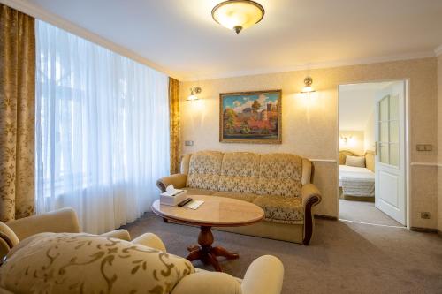 a living room with a couch and a table at Villa Basileia Riverside in Karlovy Vary