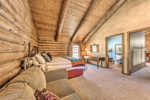 a log cabin bedroom with a bed and a couch at Cozy Alto Cabin on 2 Acres Near Fishing and Skiing! in Alto