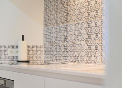 a kitchen with a tile wall and a counter top at Gezellig appartement op 100m van zee te Middelkerke in Middelkerke