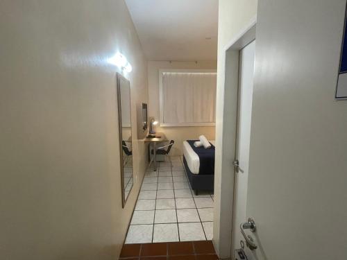 La salle de bains est pourvue de toilettes, d'un lavabo et d'un miroir. dans l'établissement Hotel de Carvalho, à Florianópolis